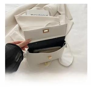 Interior capacity detail of white woven square bag holding a phone and long wallet
