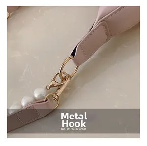 Close-up of pink leather strap with gold lobster clasp and elegant pearl charms