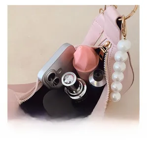 Detail showing internal capacity of pink moon bag with large pearl strap and phone