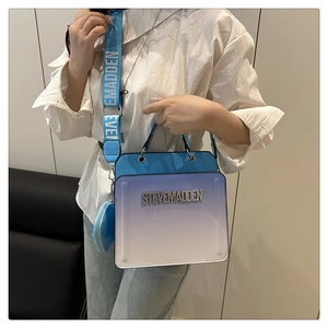 Detail of blue gradient crossbody bag featuring metallic logo and adjustable wide strap
