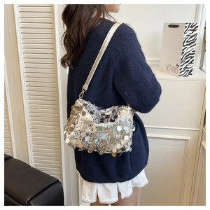 Silver sequin shoulder bag detail with metallic finish and zipper closure on a model