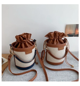 Detail view of retro color-block canvas bucket bags with leather drawstring and metal logo
