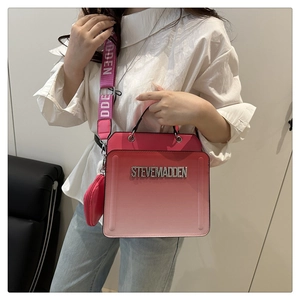Detail of gradient pink box crossbody bag with crystal logo and branded wide strap
