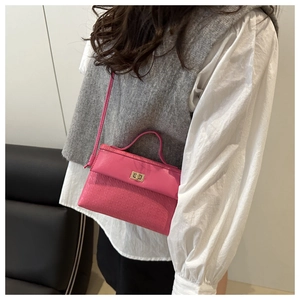 Detail of pink contrast Kelly bag with textured leather and golden turn-lock closure