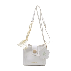 Minimalist white crossbody bucket bag with floral charm and silk scarf handle accent