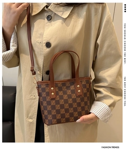 Detail of vintage checkerboard tote bag with gold rivets and detachable shoulder strap