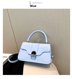 Detail of light blue crossbody bag featuring a silver metal lock and curved top handle