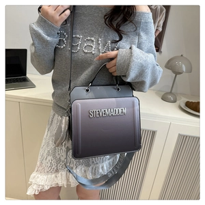 Detail of gradient crossbody bag with metallic handle and wide branded textile strap