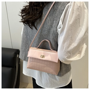 Detailed view of pink crossbody bag showing glossy flap and textured lower panel