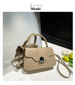Detail view of khaki leather bag with horseshoe buckle and sleek adjustable strap