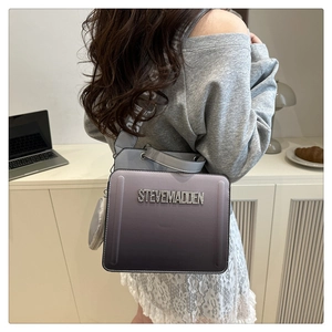 Close-up of gradient purple square crossbody bag with rhinestone logo and mini pouch