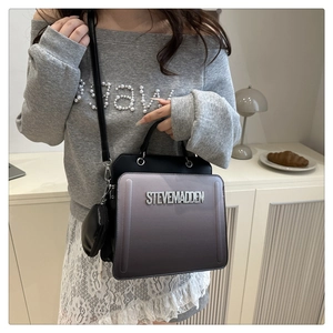 Detail of a gradient purple square handbag with metal letters and a round coin purse