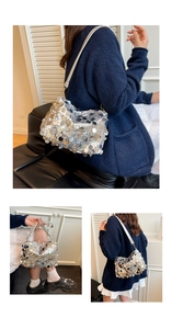 Detailed view of silver sequin shoulder bag with leather strap and golden hooks