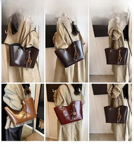Detail view of large tote bags in dark brown, caramel, and burgundy with tassel charms