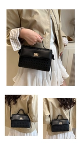 Detail of a chic black satchel featuring smooth leather and textured fabric with gold clasp