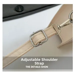 Close-up of beige shoulder bag showing adjustable strap with silver metal buckle and hook