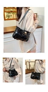 Detail of glossy black sequins and gold metal buckle on a stylish underarm bag