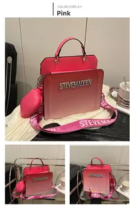 Detailed view of pink gradient handbag with heart charm and wide logo woven strap