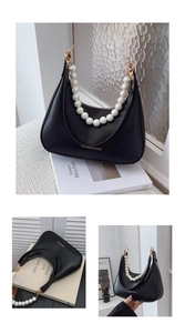 Detail of black crescent handbag with large pearl strap and gold hardware accents