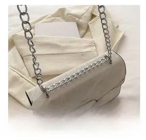 Detail of white marble print crossbody bag with silver chain strap and rhinestone buckle