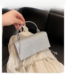 Detail view of silver evening bag featuring full rhinestone mesh and metal ring handle