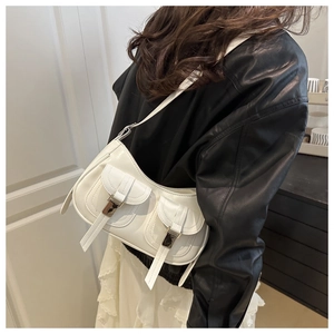 Dettaglio laterale della borsa a mezzaluna in pelle bianca con tasche decorative e fibbie