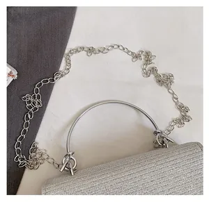 Detailed view of silver rhinestone evening bag with round metal handle and chain strap