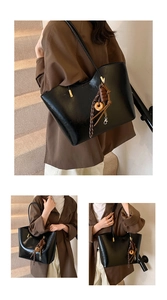 Detail of glossy black tote bag with sweet-themed charms and slim shoulder strap