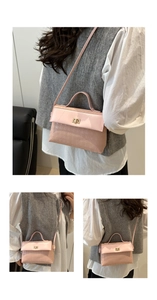 Close-up of pink textured leather handbag with gold metal clasp and top handle strap