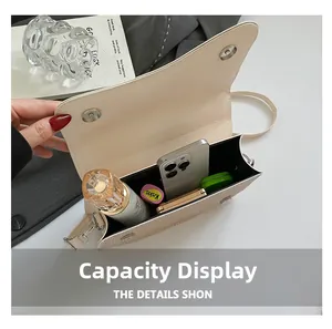 Internal view of cream leather crossbody bag showing capacity for phone and perfume