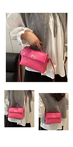 Detail of fuchsia pink winged handbag showing gold twist lock and textured surface