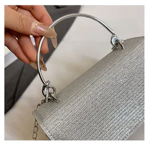 Macro detail of silver rhinestone evening bag with round metal handle and sparkling surface