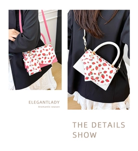 Detail of strawberry print crossbody bag with matching card holder and detachable strap