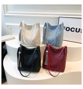 Detail of four plaid bucket bags with textured lettering and decorative tassels with beads