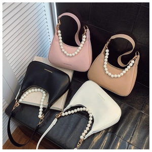 Close-up of stylish crescent moon underarm bags with pearl straps in four diverse colors