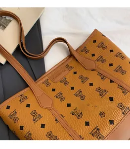 Detailed close-up of caramel lychee grain tote bag with bear pattern and leather straps
