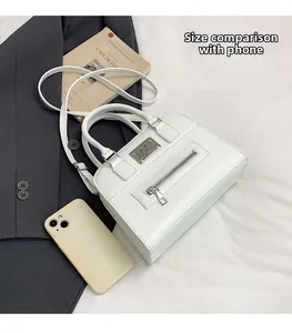 Detailed comparison of white faux leather Boston bag size with a smartphone for scale