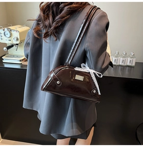 Borsa bowling marrone lucida con fiocco in pizzo bianco in un caffè elegante