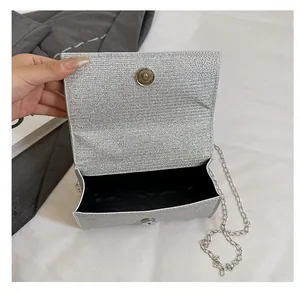 Internal view of a silver sequined clutch bag showing black lining and metal chain strap