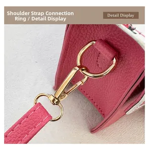 Macro shot of gold hardware and stitching on magenta textured leather shoulder bag