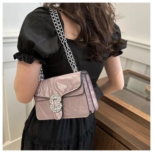 Detail of crossbody bag with marble pattern, silver chain strap and diamond buckle