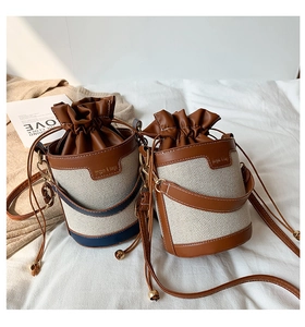 Detailed view of canvas and leather bucket bags with drawstring closure and chic contrast trim