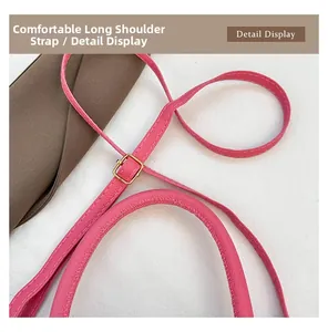Detail of pink pebbled leather shoulder bag strap with gold metal adjustment buckle