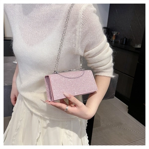 Close-up of sparkling pink sequin evening clutch bag with elegant silver metal handle