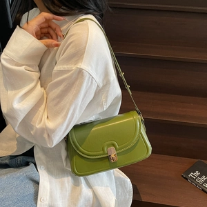 Retro avocado green leather shoulder bag with gold clasp shown on a model