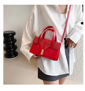 Detail of red glitter flap handbag with golden twist lock on white shirt outfit
