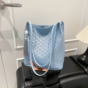 Light blue large tote bag with luxury logo pattern and long tassel detail for summer