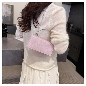 Pink sequin evening clutch bag with round metal handle and delicate silver chain strap
