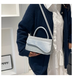 Detailed view of silver sequin bag with asymmetric flap and round metallic handle