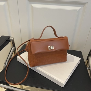 Brown leather handbag with embossed geometric pattern and golden twist lock for women
